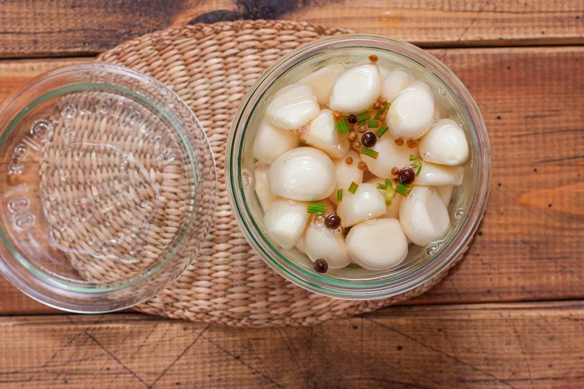 Top-down view of spicy pickled garlic in a canning jar.