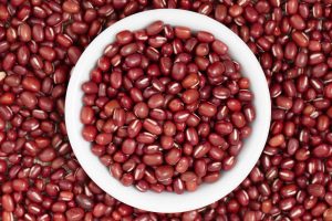 Top down view of a white bowl full of red adzuki beans.